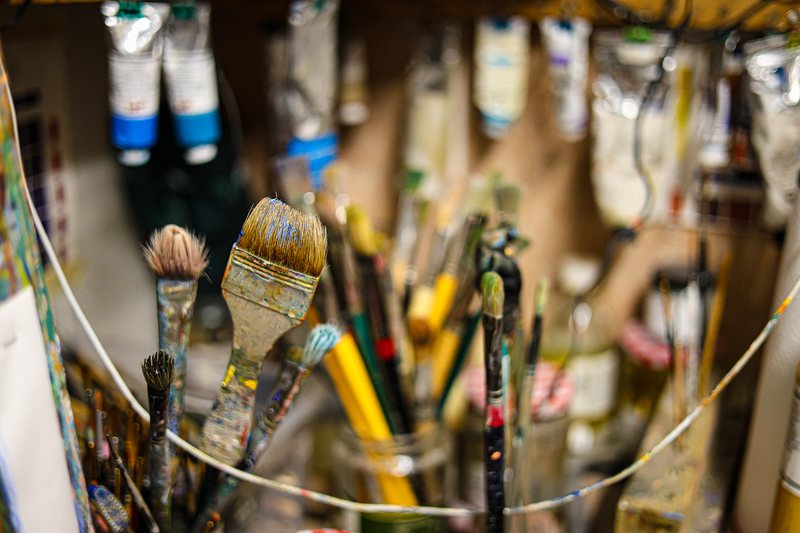 Well-used brushes standing in jars in the studio